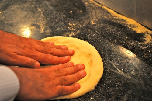 spreading pizza dough